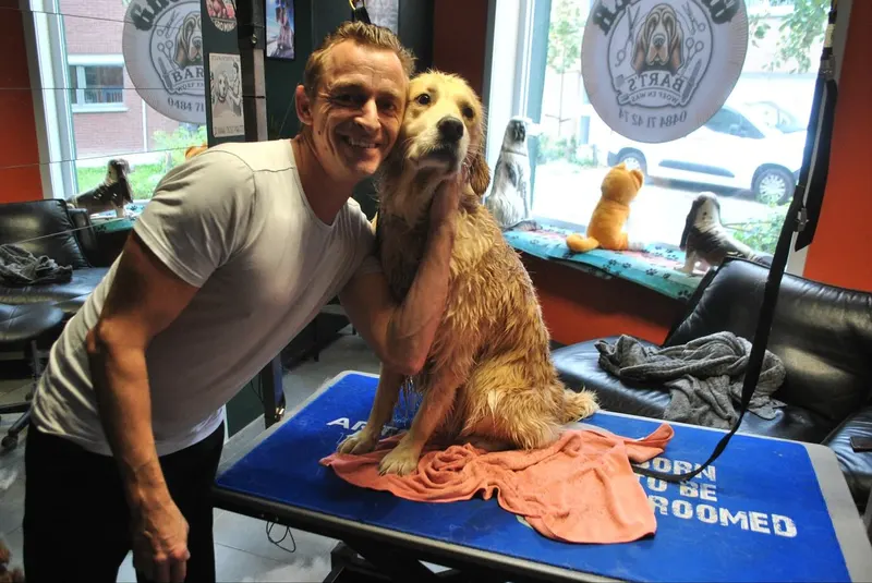 Bart knuffelt een golden retriever na het bad